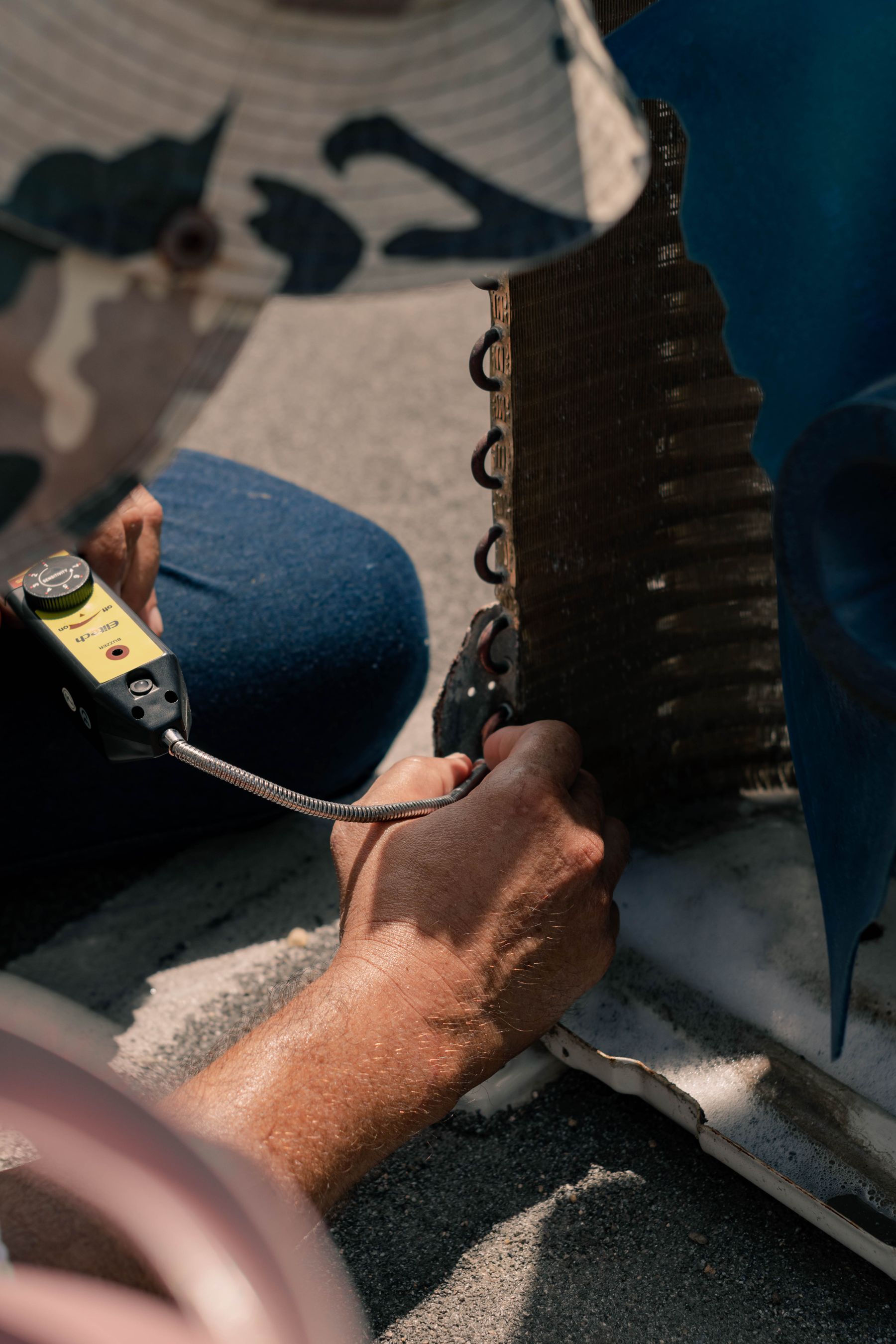 Technician checking an air-conditioning unit with a handheld instrument